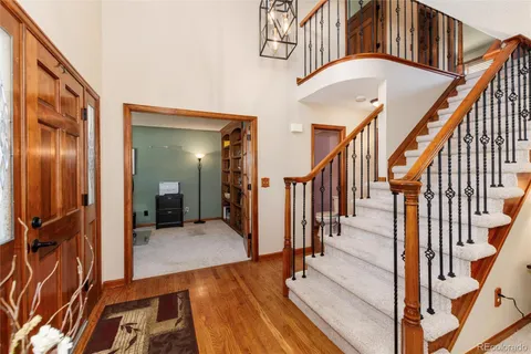 a view of a hallway with wooden floor and staircase