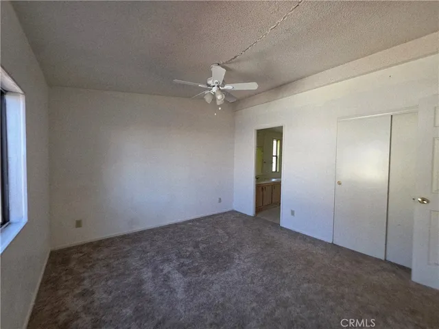 an empty room with fan and entrance