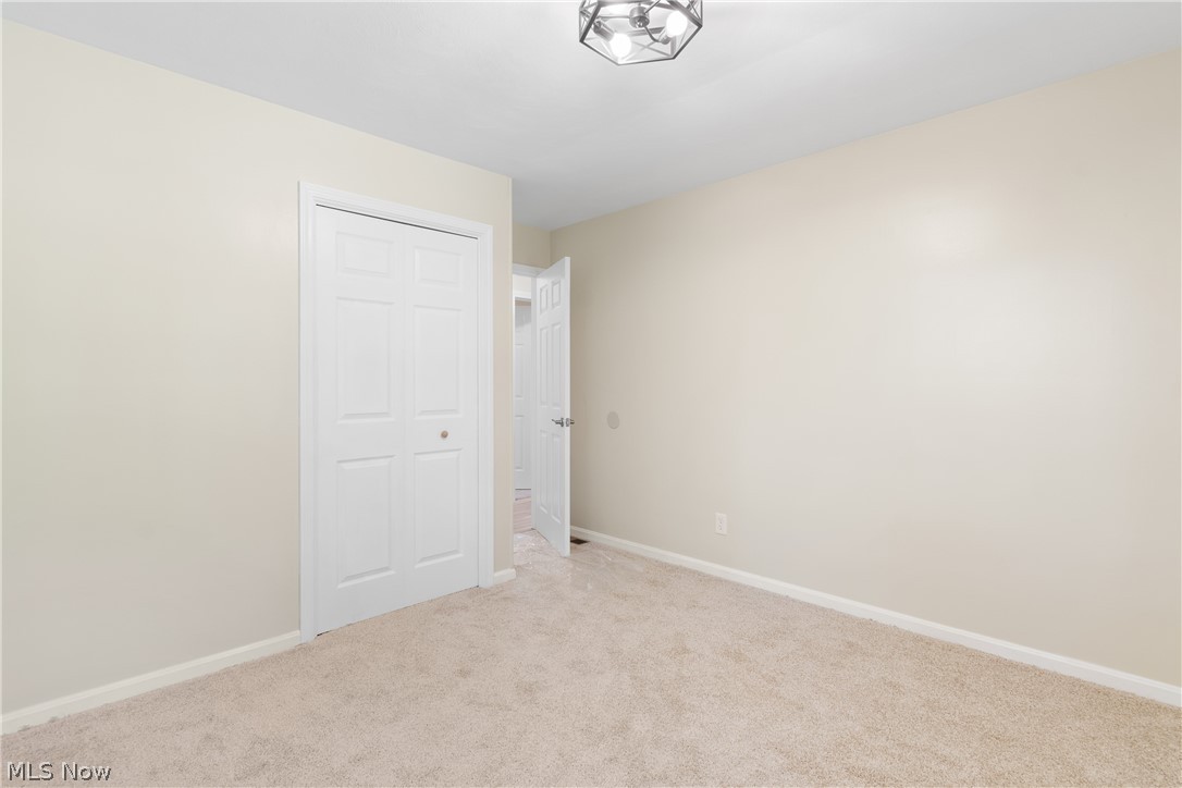 1075 Northeast River Road Lake Milton, OH 44429 - Photo 20 of 34 Neutral wall paint with crown molding and light-colored carpeting