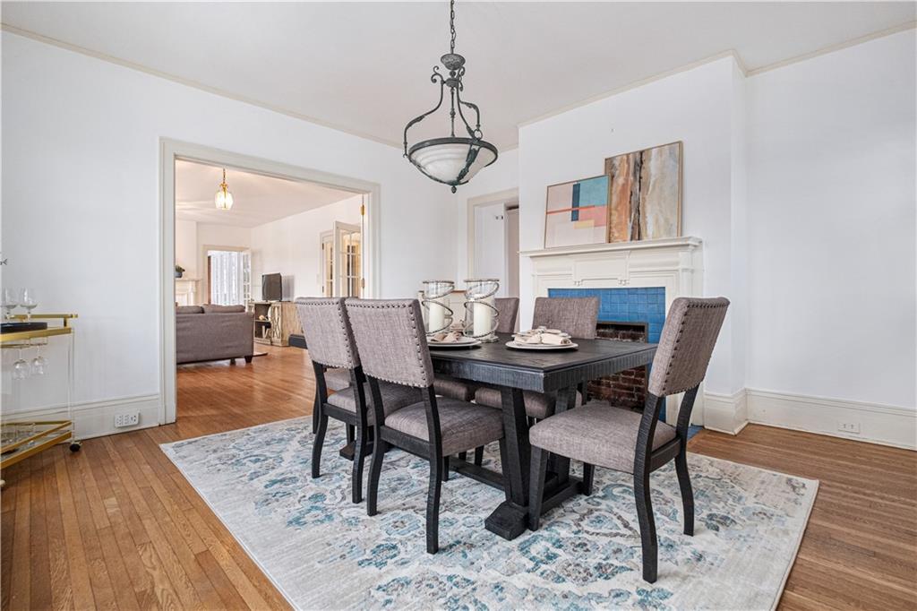 4305 Centre Pittsburgh, PA 15213 - Photo 14 of 47 a dining room with wooden floor a chandelier a wooden table and chairs