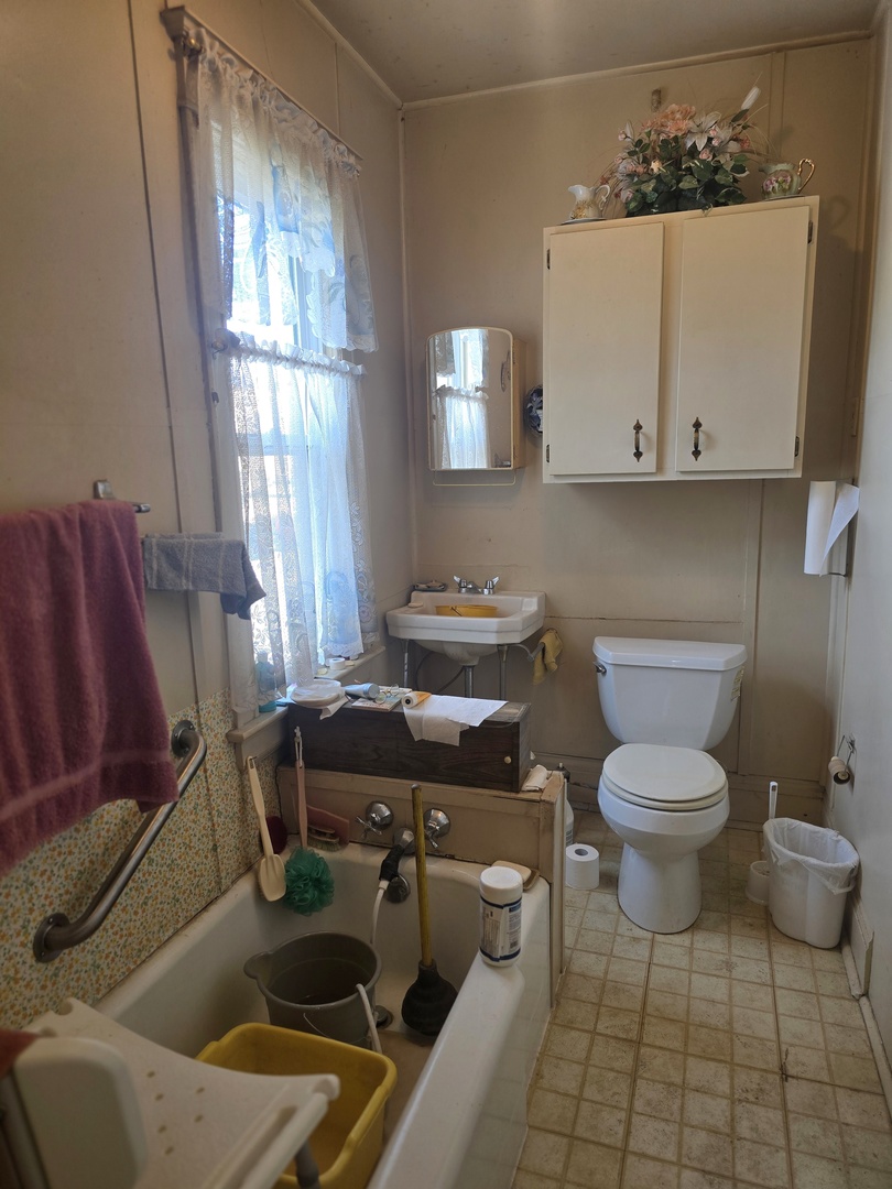 157-159 West Hickory Street Kankakee, IL 60901 - Photo 21 of 33 a bathroom with a toilet a sink and a mirror