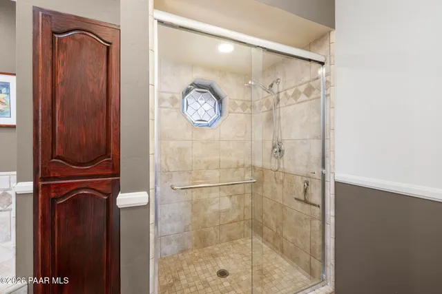 a view of an empty room with a window and a kitchen