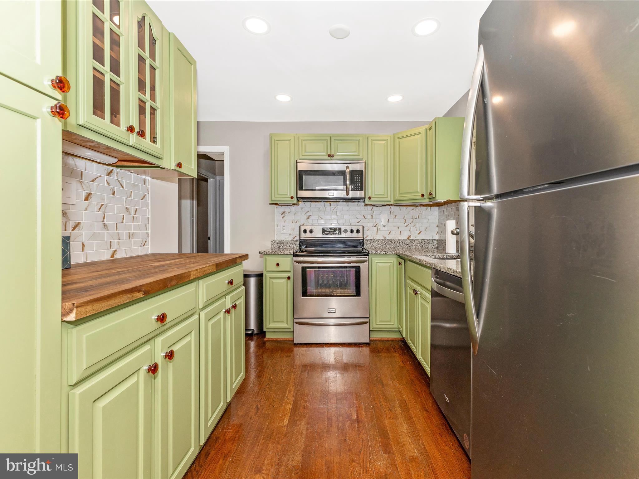 12230 Selfridge Road Silver Spring, MD 20906 - Photo 13 of 49 a kitchen with stainless steel appliances granite countertop a stove and a refrigerator