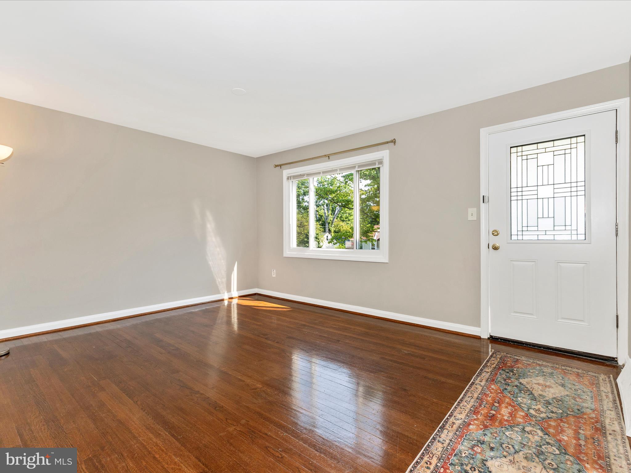 12230 Selfridge Road Silver Spring, MD 20906 - Photo 2 of 49 an empty room with wooden floor and windows
