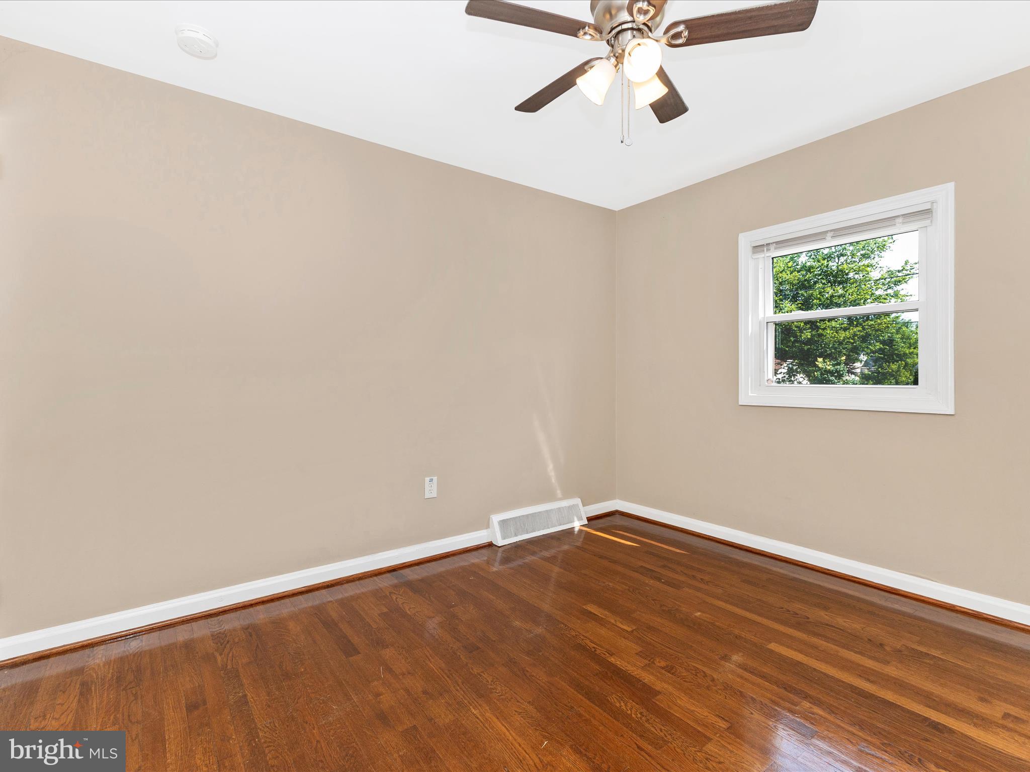 12230 Selfridge Road Silver Spring, MD 20906 - Photo 27 of 49 an empty room with wooden floor fan and windows