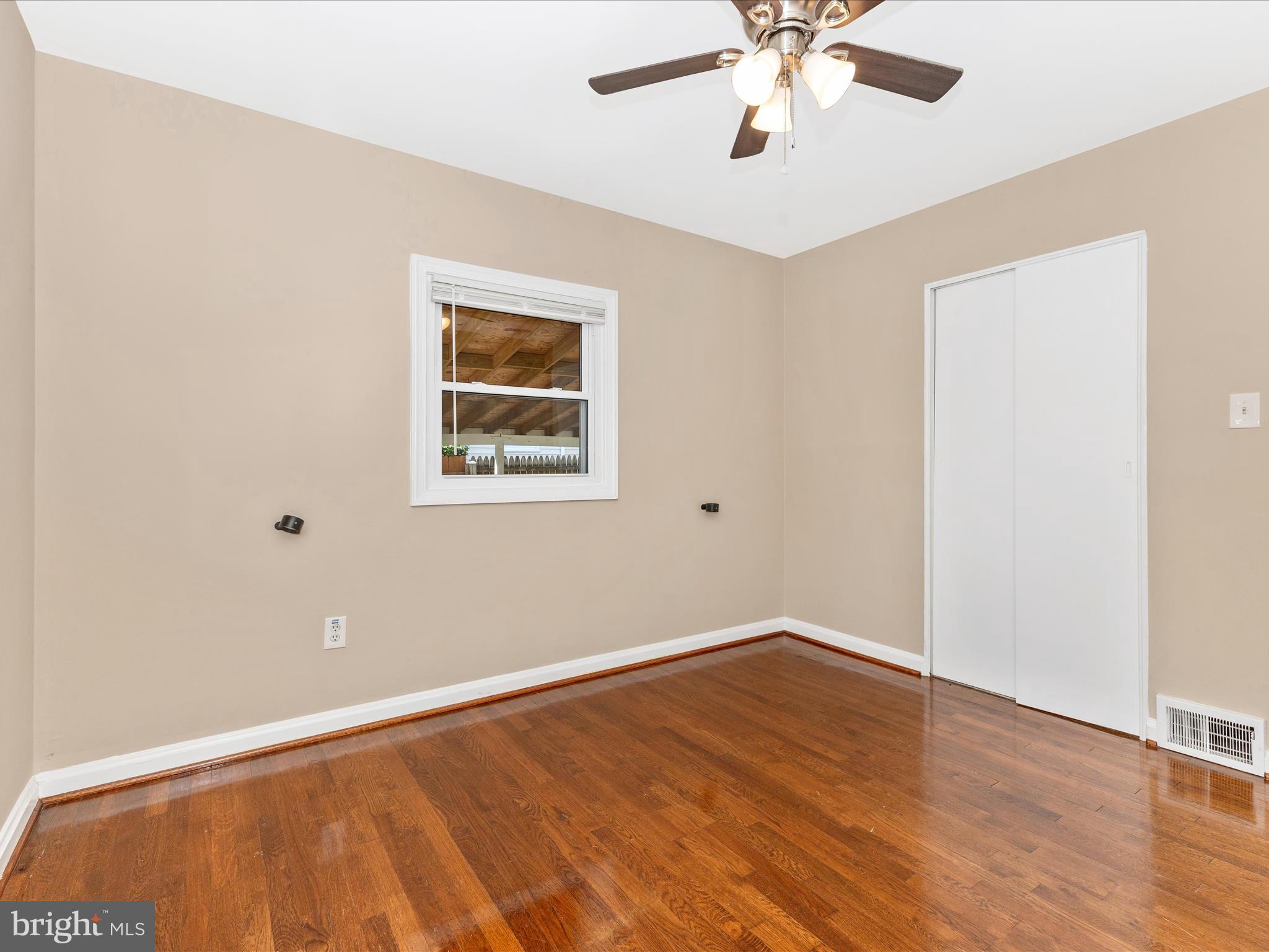 12230 Selfridge Road Silver Spring, MD 20906 - Photo 30 of 49 a view of an empty room with wooden floor and a ceiling fan