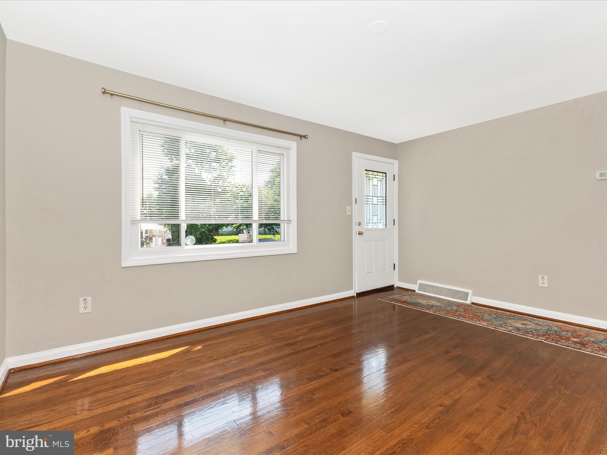 12230 Selfridge Road Silver Spring, MD 20906 - Photo 4 of 49 a view of an empty room with wooden floor and a window