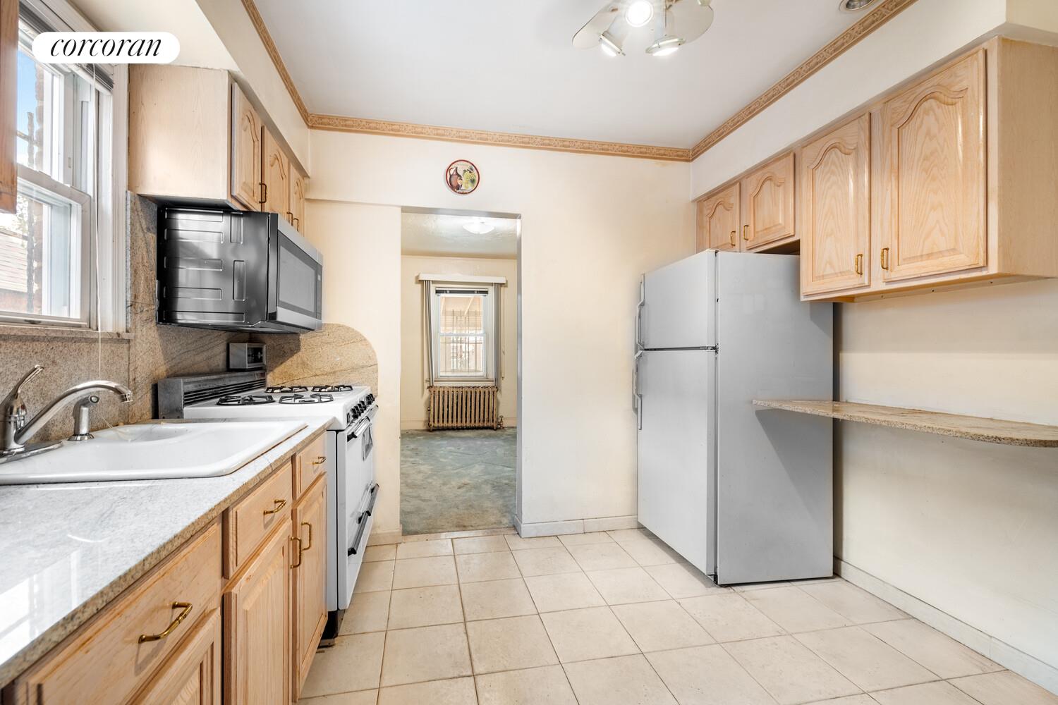 187-23 Brinkerhoff Avenue Queens, NY 11412 - Photo 2 of 10 a kitchen with a refrigerator sink stove and cabinets