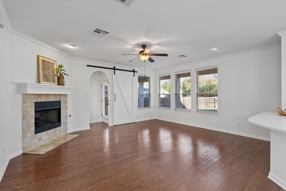 422 Village Commons Boulevard Georgetown, TX 78633 - Photo 12 of 40 a view of an empty room with wooden floor fireplace and a window