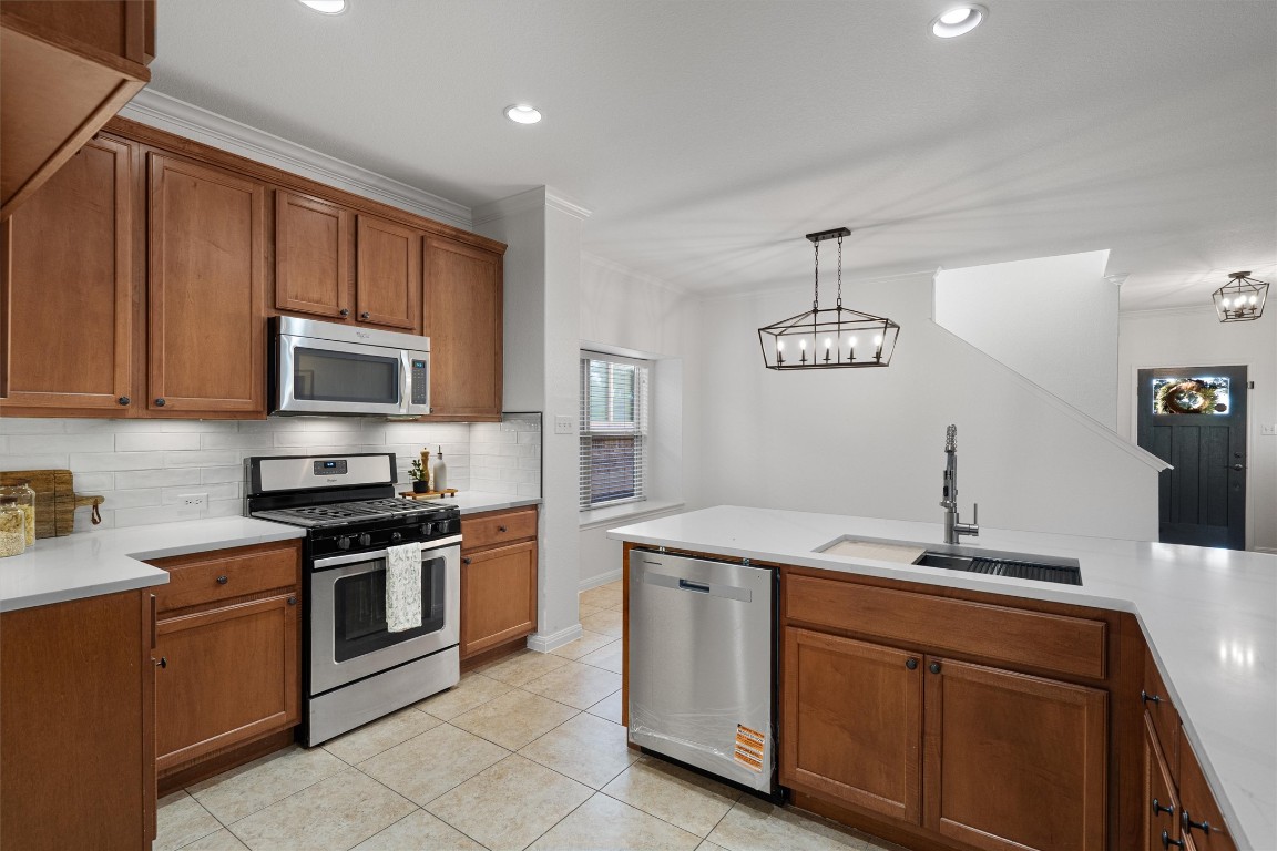 422 Village Commons Boulevard Georgetown, TX 78633 - Photo 15 of 40 a kitchen with stainless steel appliances granite countertop a sink stove and microwave