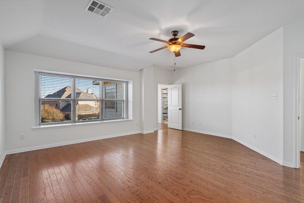 422 Village Commons Boulevard Georgetown, TX 78633 - Photo 24 of 40 a view of an empty room with a window and wooden floor