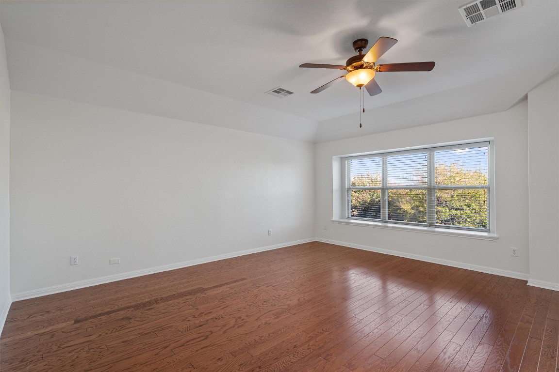 422 Village Commons Boulevard Georgetown, TX 78633 - Photo 26 of 40 a view of an empty room with wooden floor and a window