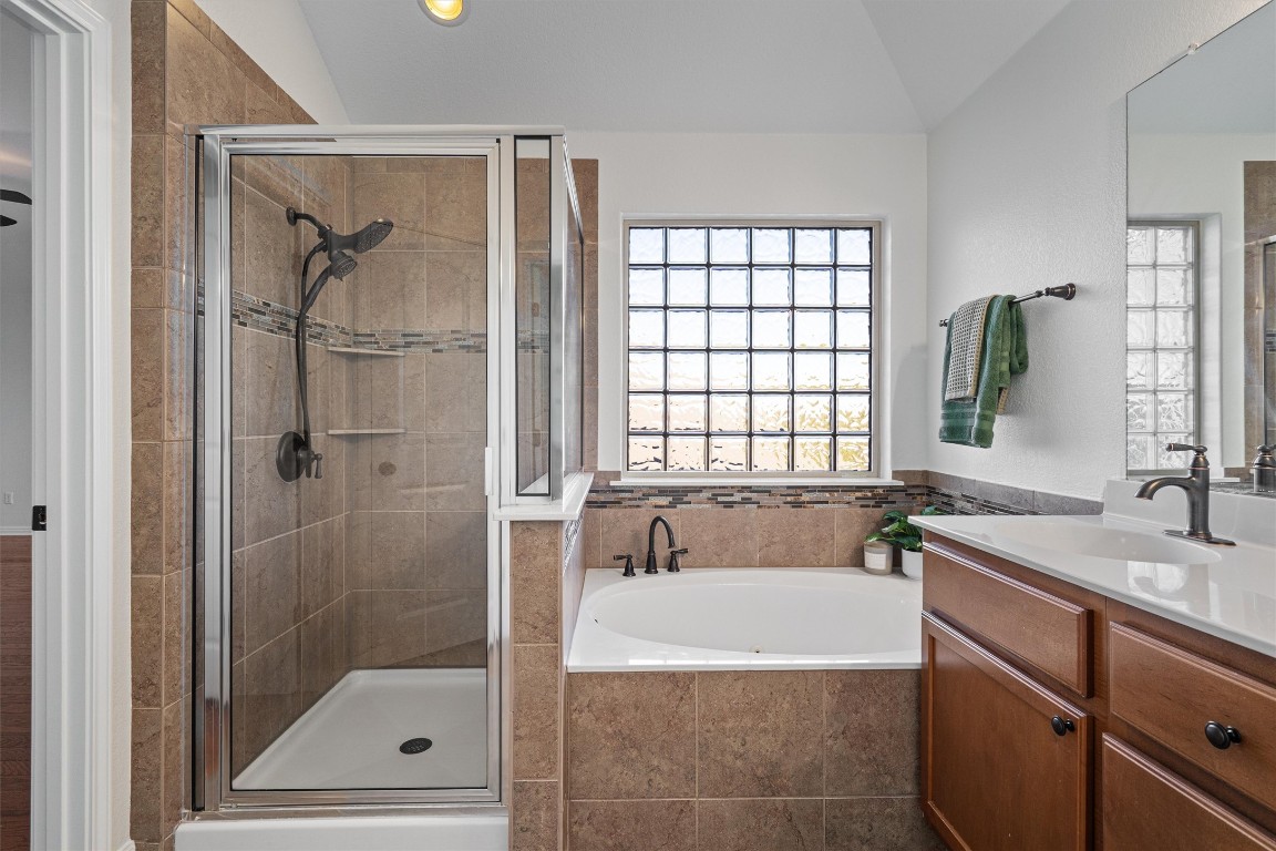 422 Village Commons Boulevard Georgetown, TX 78633 - Photo 27 of 40 a bathroom with a granite countertop bathtub shower sink and mirror