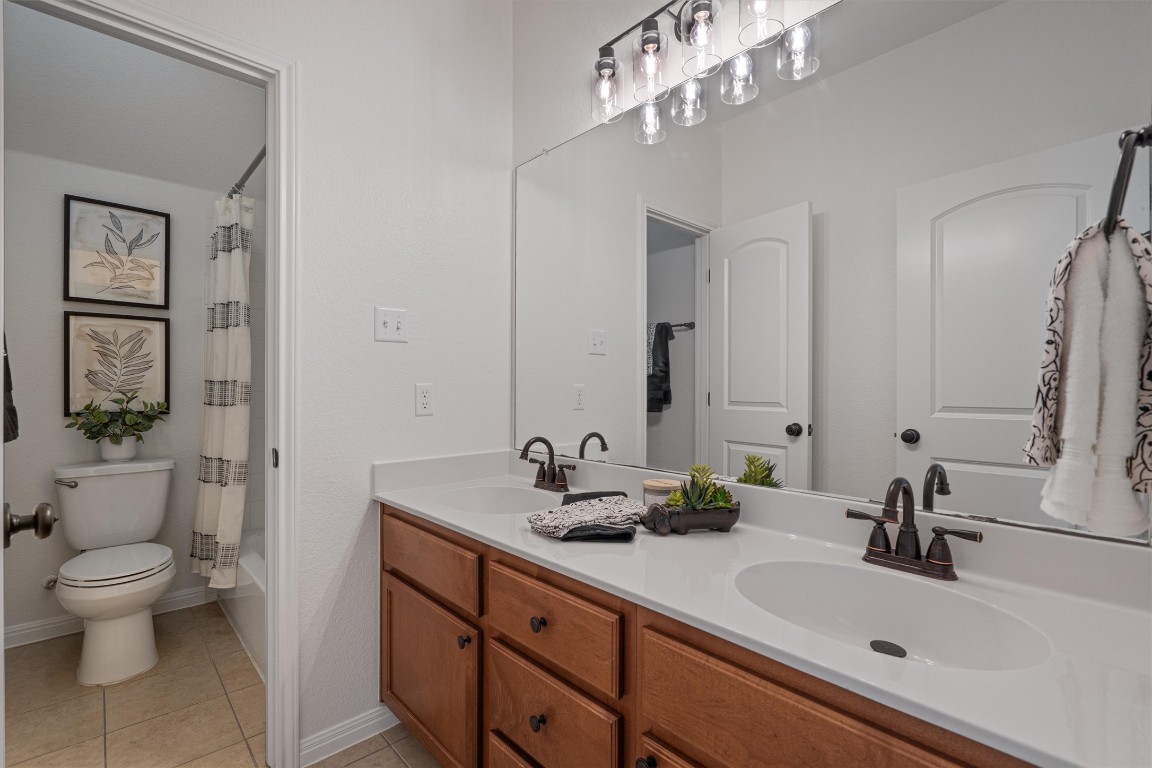 422 Village Commons Boulevard Georgetown, TX 78633 - Photo 30 of 40 a bathroom with a sink a toilet and a mirror