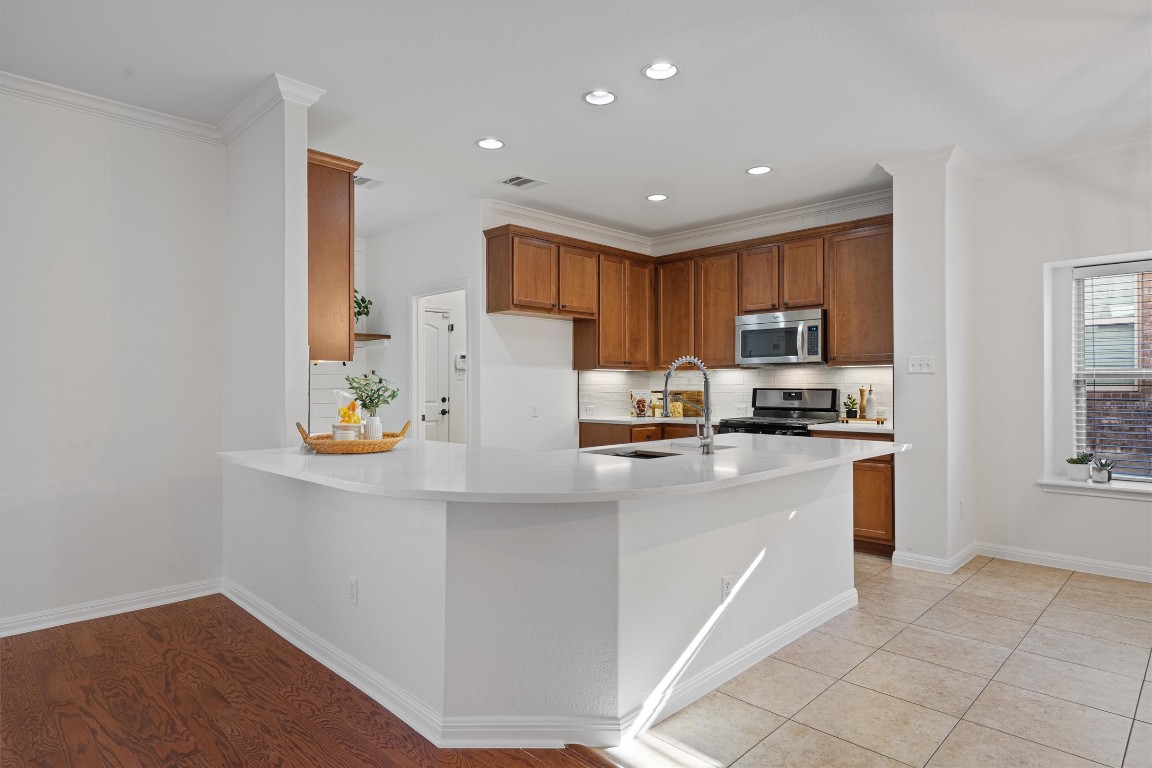 422 Village Commons Boulevard Georgetown, TX 78633 - Photo 3 of 40 a kitchen with stainless steel appliances a refrigerator sink and microwave
