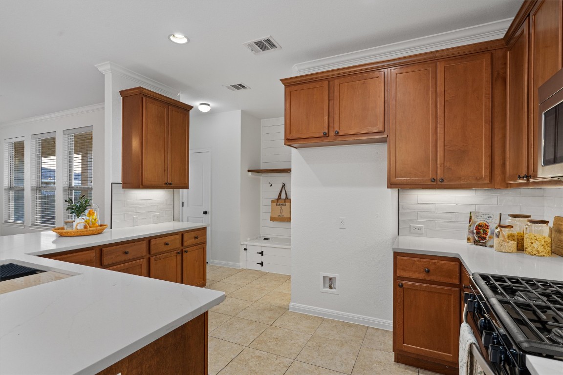 422 Village Commons Boulevard Georgetown, TX 78633 - Photo 4 of 40 a kitchen with stainless steel appliances a stove a sink and a refrigerator