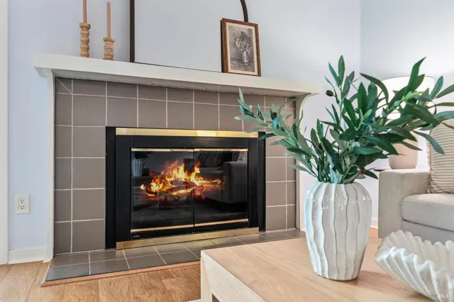 a living room with furniture a fireplace and a potted plant