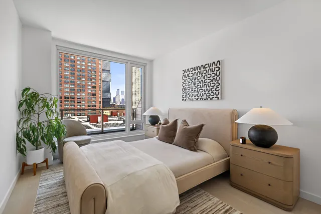 a bedroom with a large bed and a potted plant