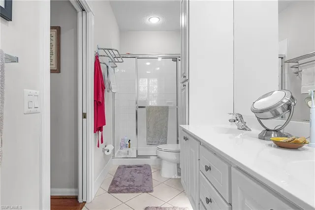 a bathroom with a granite countertop sink a toilet and shower