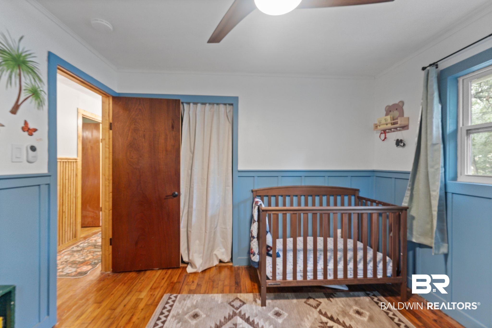 10785 Gregg Road Semmes, AL 36575 - Photo 20 of 35 Bedroom with a wainscoted wall, wood finished floors, a ceiling fan, a nursery area, and crown molding