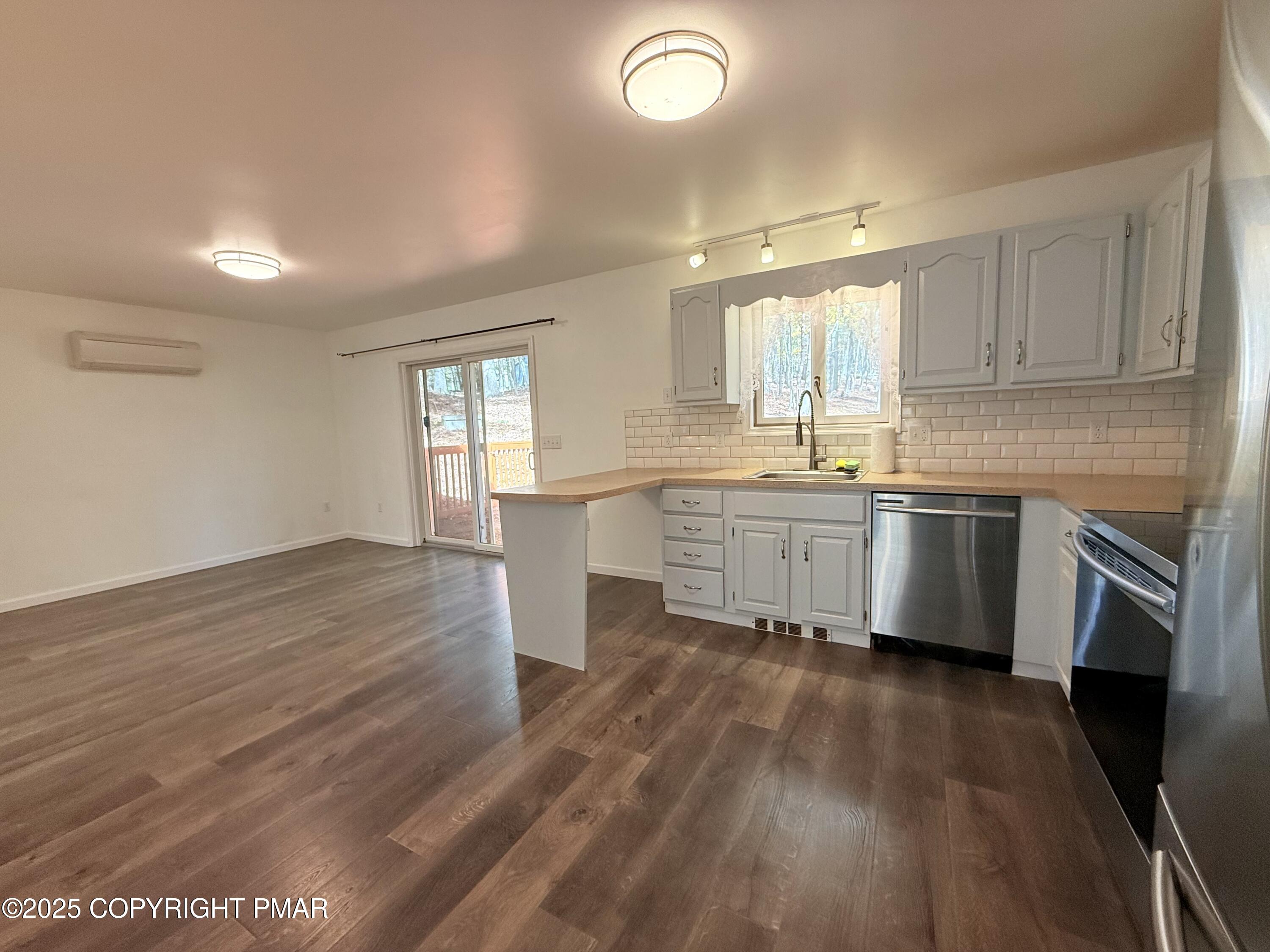 303 Otter Court Bushkill, PA 18324 - Photo 3 of 18 a kitchen with a sink wooden floor and stainless steel appliances