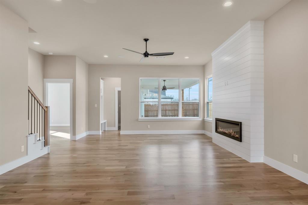 207 West 7th Street Justin, TX 76247 - Photo 13 of 40 a view of an empty room with wooden floor and a window