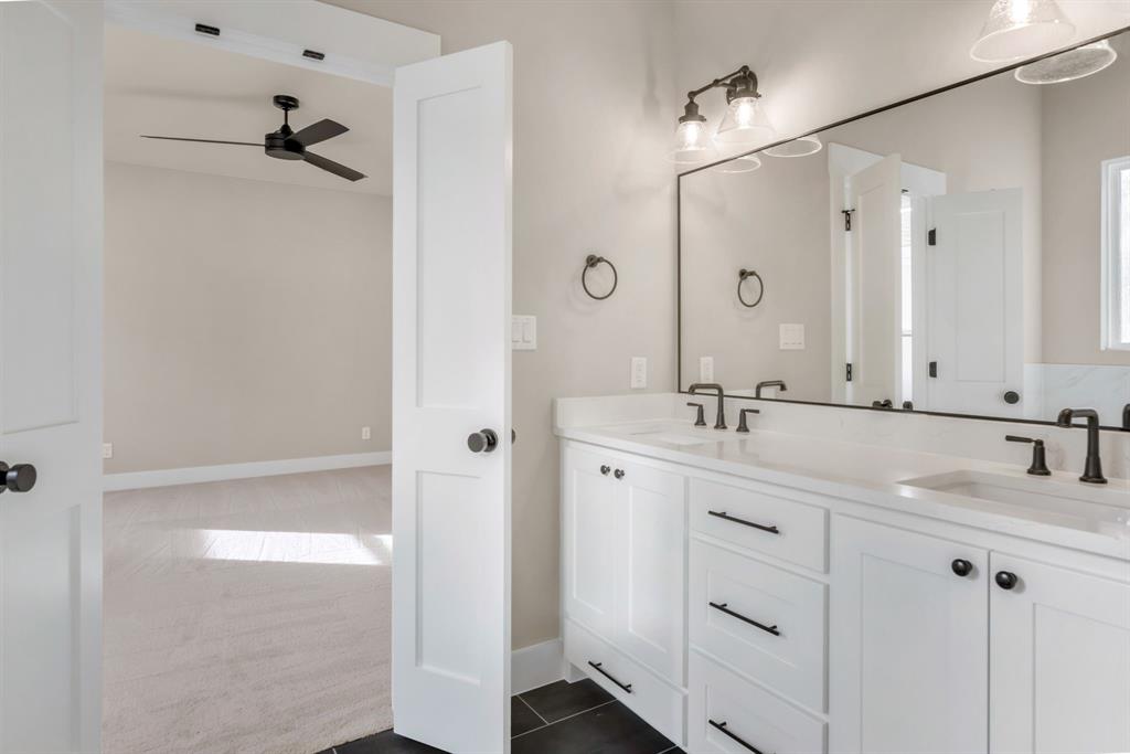 207 West 7th Street Justin, TX 76247 - Photo 20 of 40 a bathroom with a double vanity sink mirror and shower