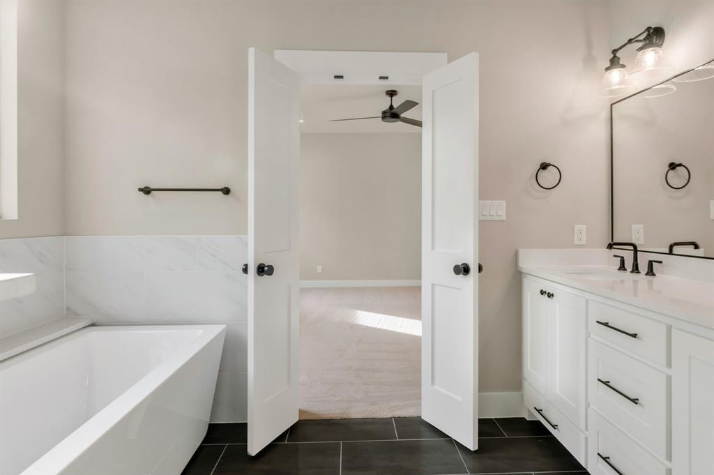 207 West 7th Street Justin, TX 76247 - Photo 23 of 40 a bathroom with a tub sink and mirror