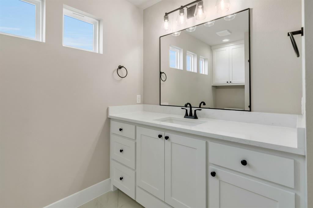 207 West 7th Street Justin, TX 76247 - Photo 31 of 40 a bathroom with a sink and a mirror