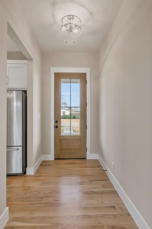 207 West 7th Street Justin, TX 76247 - Photo 6 of 40 a view of an empty room with wooden floor and a window