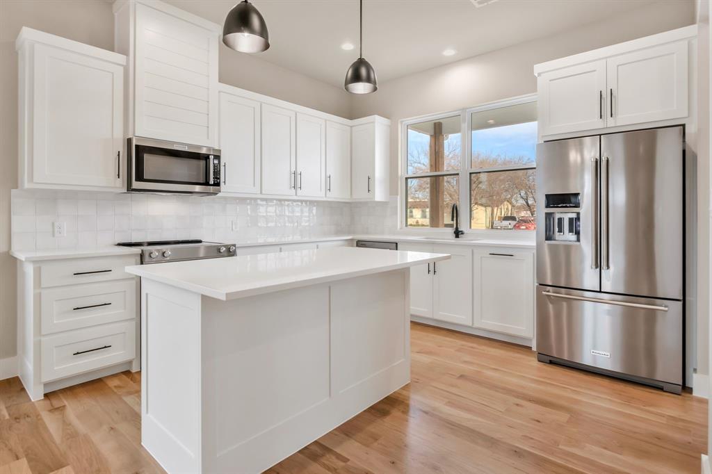 207 West 7th Street Justin, TX 76247 - Photo 7 of 40 a kitchen with appliances a sink and a refrigerator