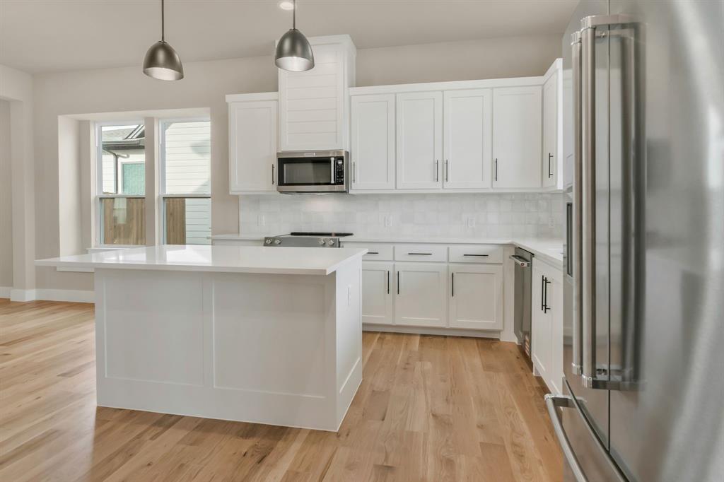 207 West 7th Street Justin, TX 76247 - Photo 8 of 40 a kitchen with stainless steel appliances granite countertop a stove a sink and a refrigerator