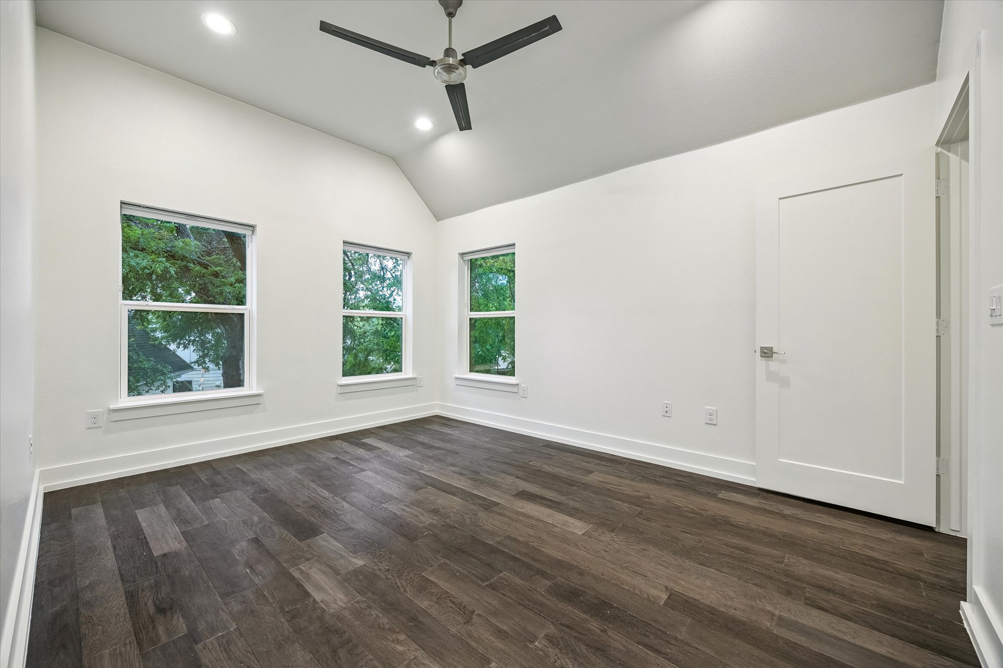 1224 Eleanor Street, Unit 1 Austin, TX 78721 - Photo 11 of 18 an empty room with wooden floor ceiling fan and windows