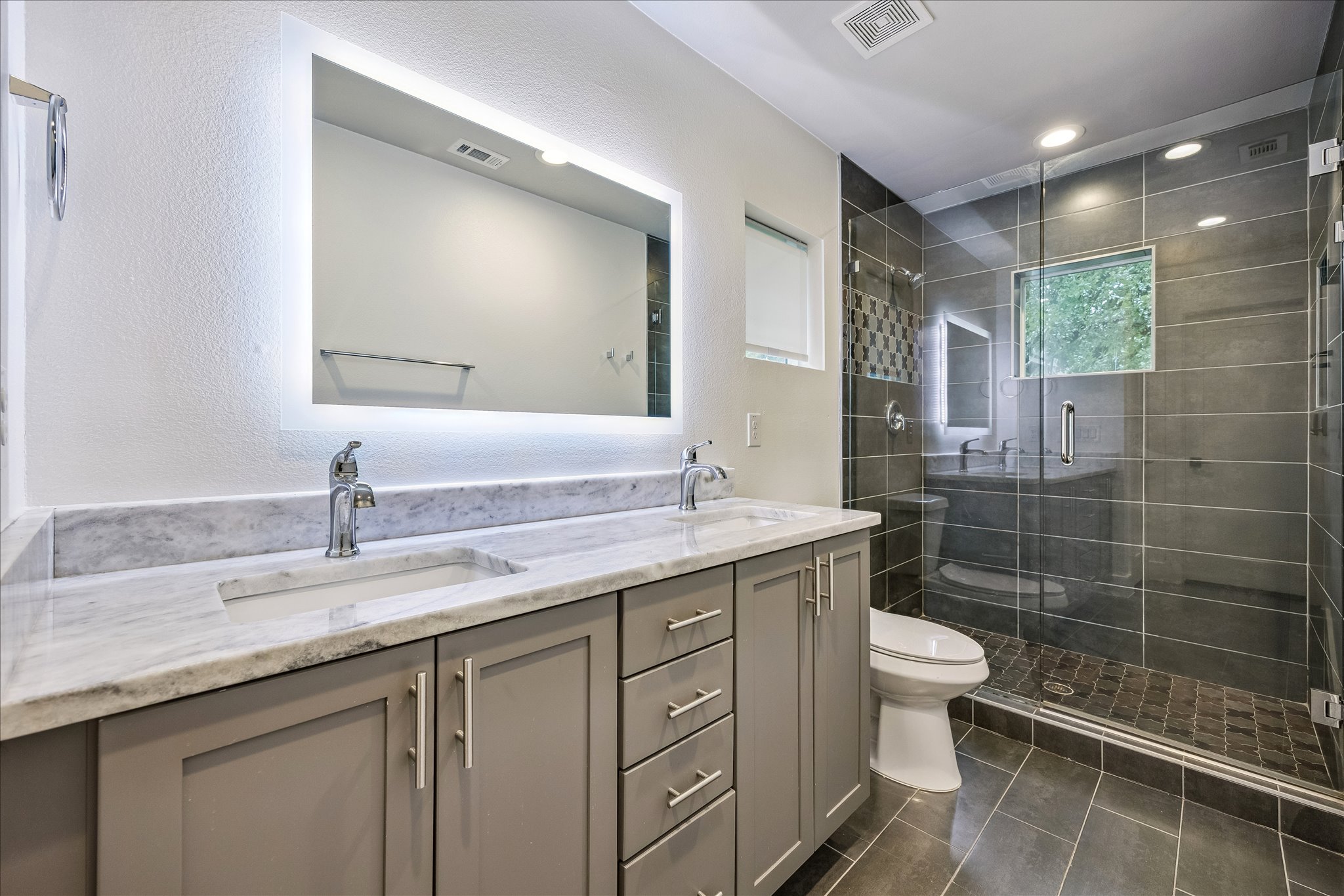 1224 Eleanor Street, Unit 1 Austin, TX 78721 - Photo 12 of 18 a bathroom with a granite countertop sink a toilet a mirror and shower