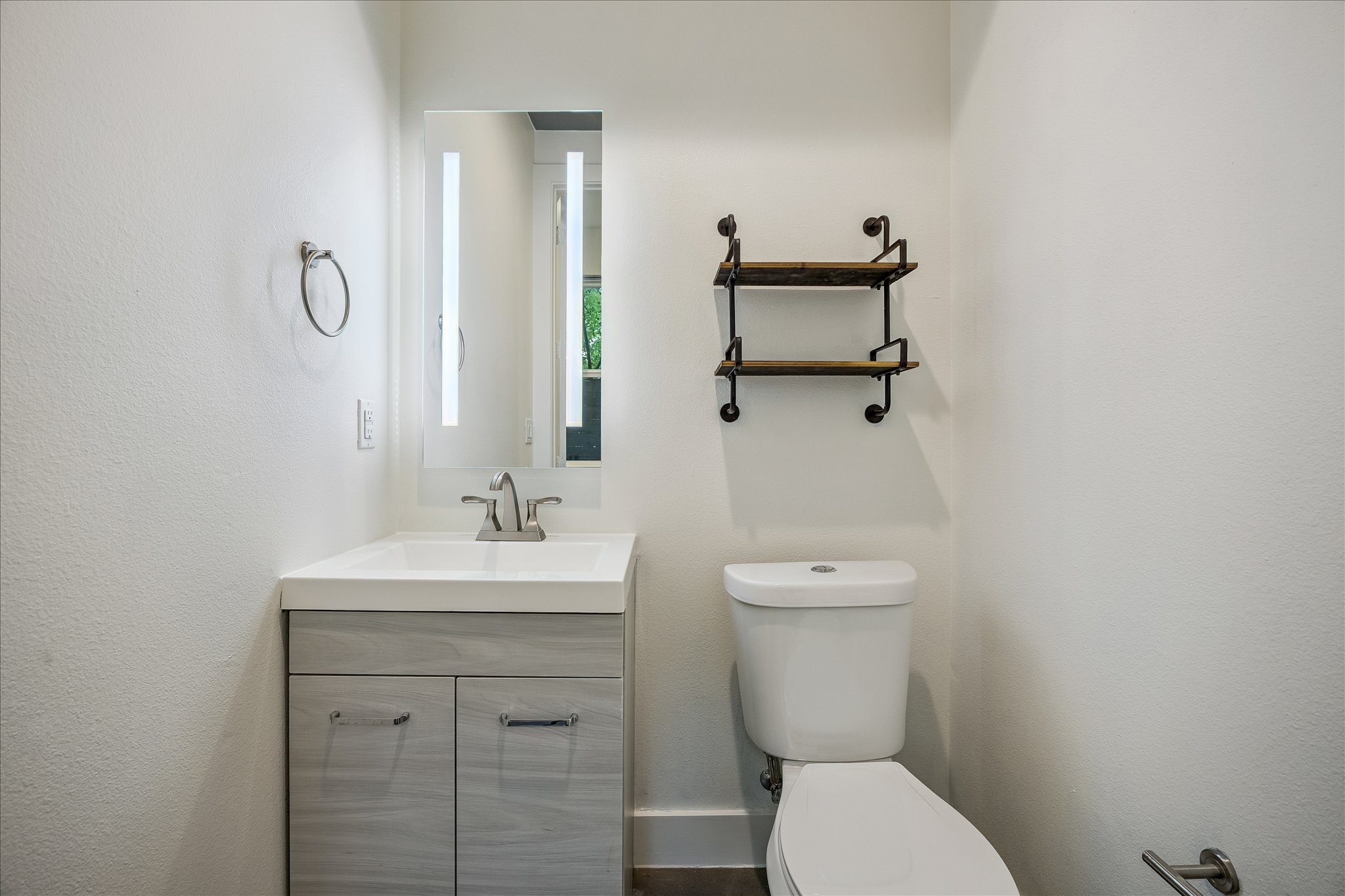 1224 Eleanor Street, Unit 1 Austin, TX 78721 - Photo 10 of 18 a bathroom with a toilet a sink and mirror