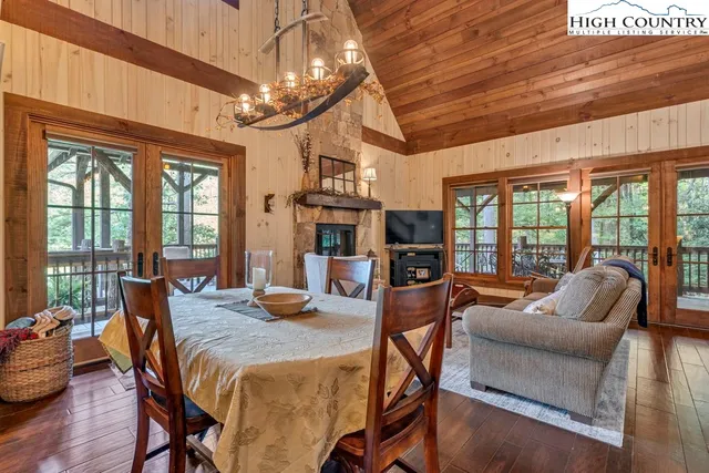 a living room with furniture a flat screen tv and large windows