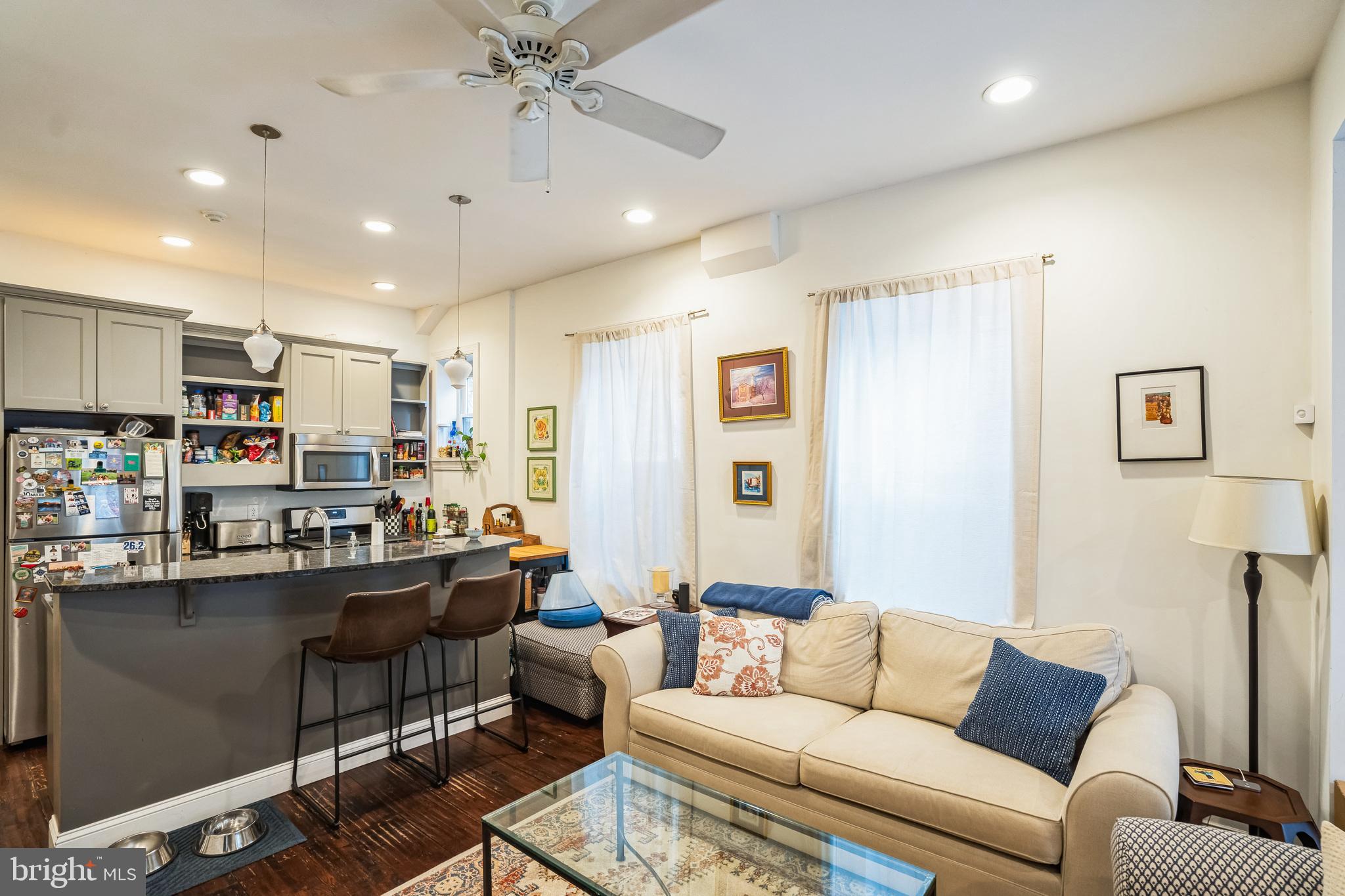 2124 Spruce Street, Unit 1R Philadelphia, PA 19103 - Photo 7 of 17 a living room with stainless steel appliances kitchen island granite countertop furniture and a couch