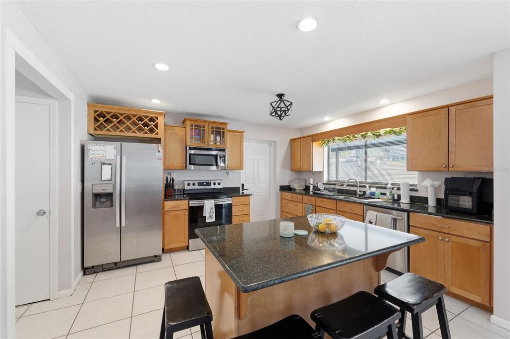 12935 Rain Forest Street Temple Terrace, FL 33617 - Photo 12 of 51 a kitchen with a table chairs microwave and refrigerator