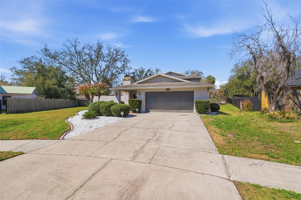 12935 Rain Forest Street Temple Terrace, FL 33617 - Photo 4 of 51 a front view of a house with a yard and a garage