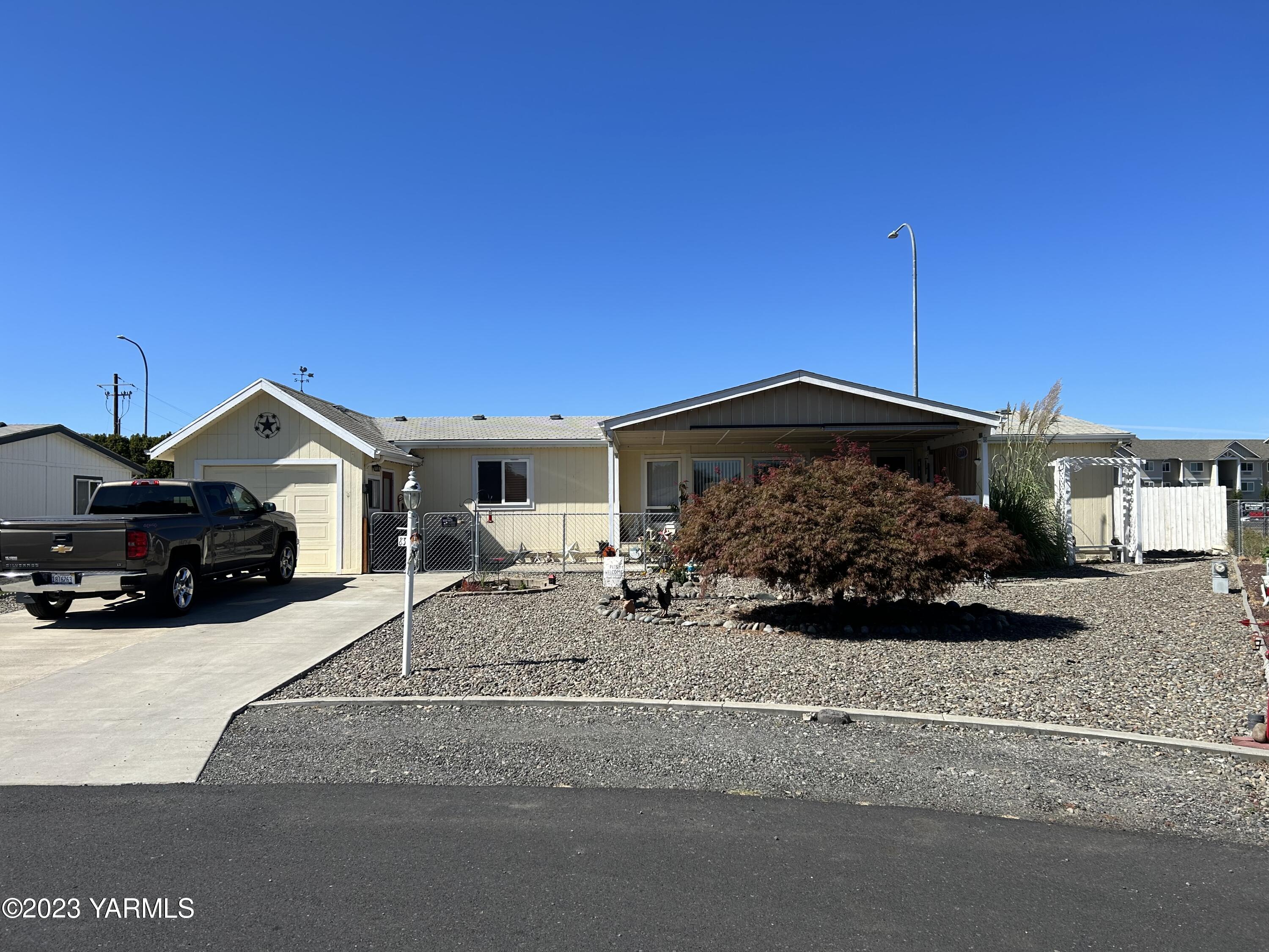 3701 Gun Club Road, Unit 83 Yakima, WA 98901 - Photo 1 of 21 a front view of a house with a yard and garage
