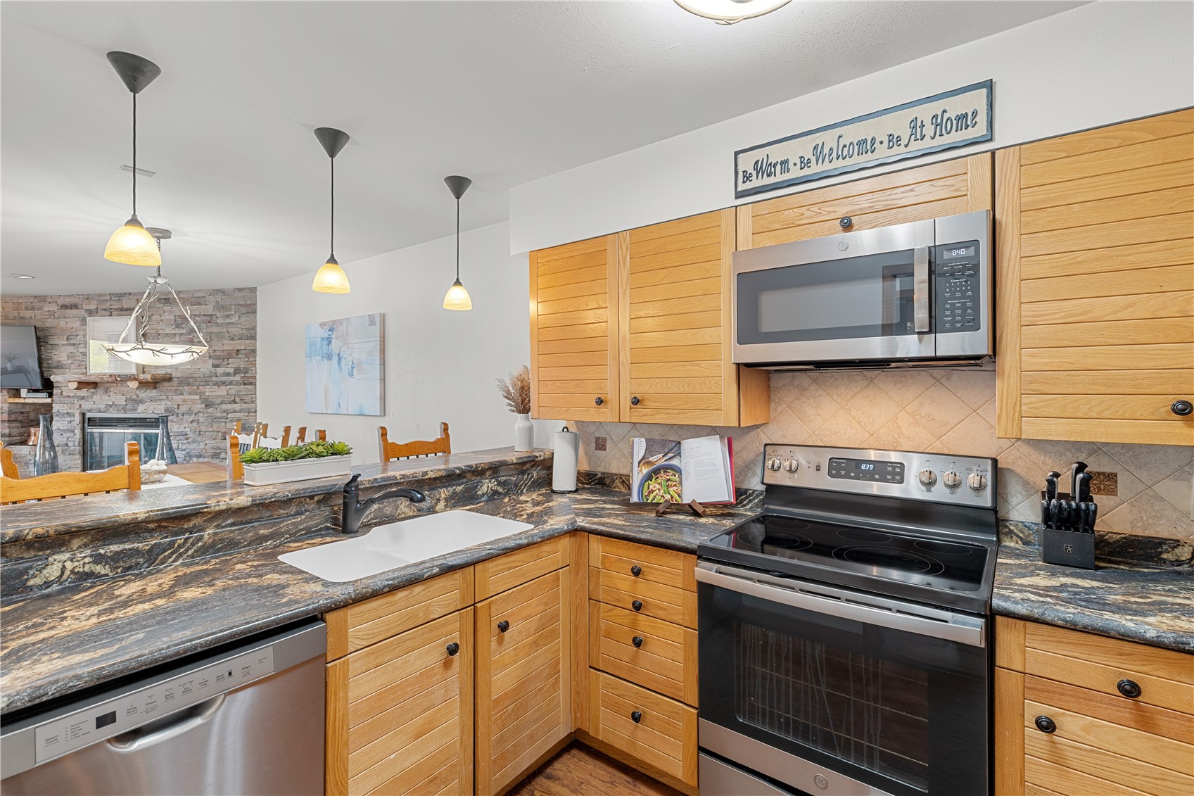22804 Highway 6, Unit 102 Keystone, CO 80435 - Photo 7 of 34 a kitchen with stainless steel appliances granite countertop a sink a stove and a wooden cabinets