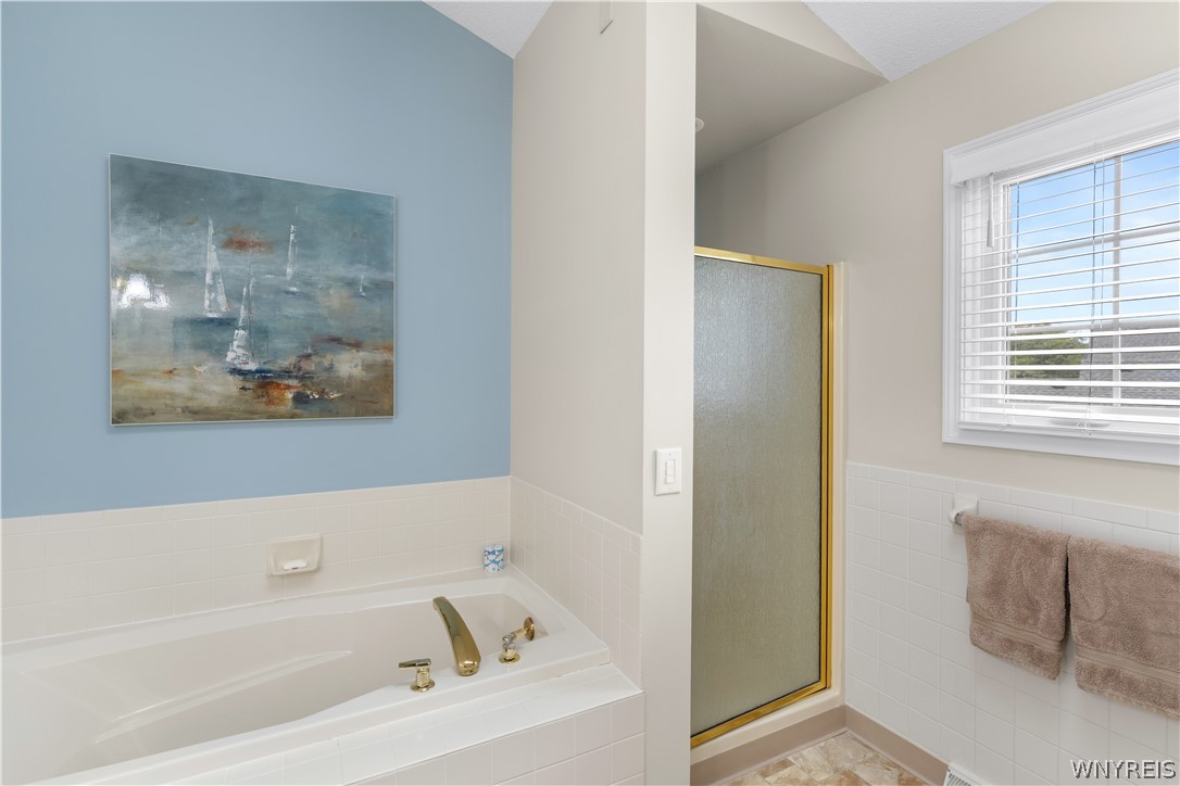 2850 Amsdell Road, Unit 34 Hamburg, NY 14075 - Photo 23 of 33 Vaulted ceilings soar over a separate soaking tub and walk-in shower layout.