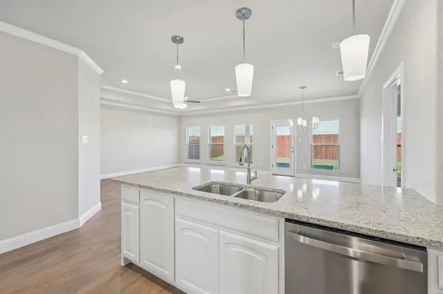 a kitchen with granite countertop a sink and a wooden floor