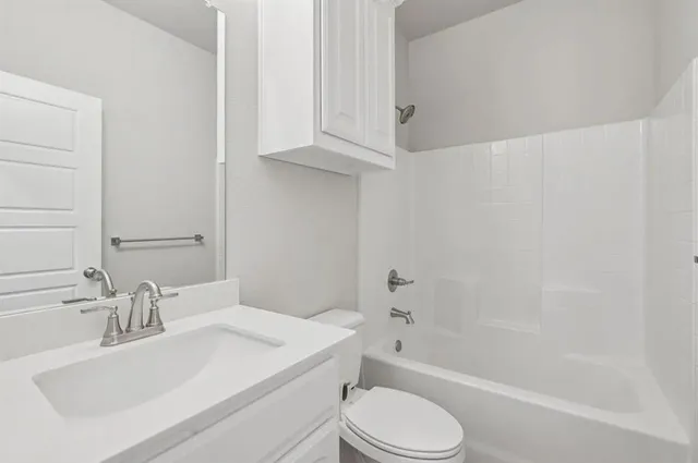a bathroom with a sink toilet vanity and bathtub