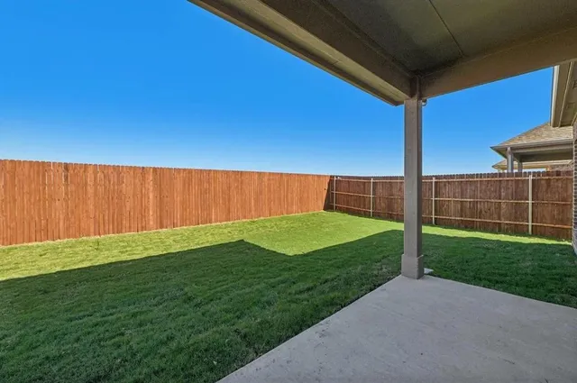a view of a backyard with wooden fence