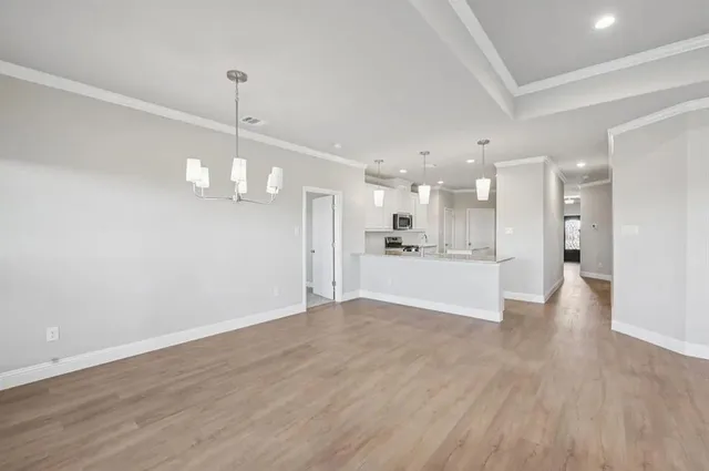 a view of an empty room and kitchen view