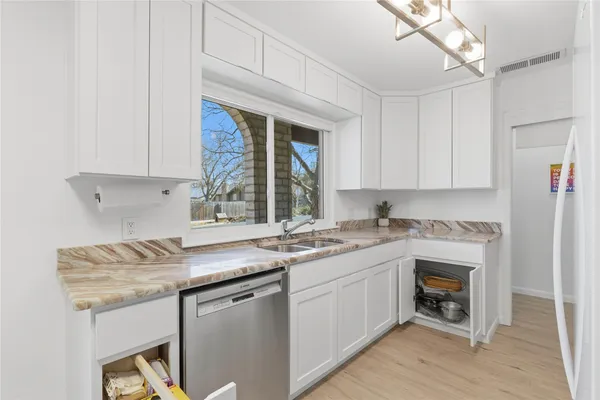 a kitchen with stainless steel appliances granite countertop a sink and a white cabinets