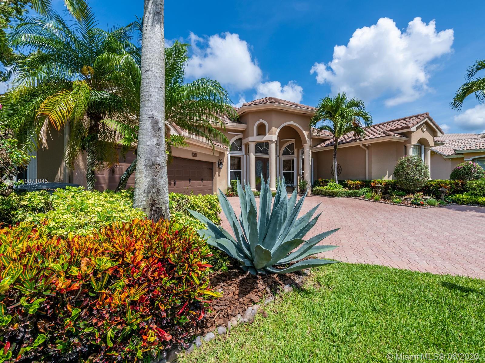 21663 Fall River Drive Boca Raton, FL 33428 - Photo 2 of 48 a view of a white house with a big yard and flower plants