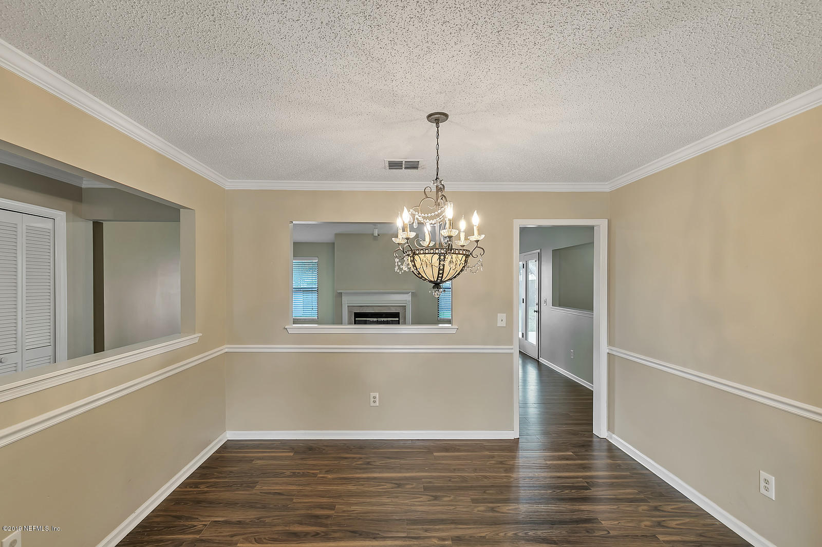 12436 Running River Road South Jacksonville, FL 32225 - Photo 12 of 25 a view of a hallway with wooden floor and chandelier