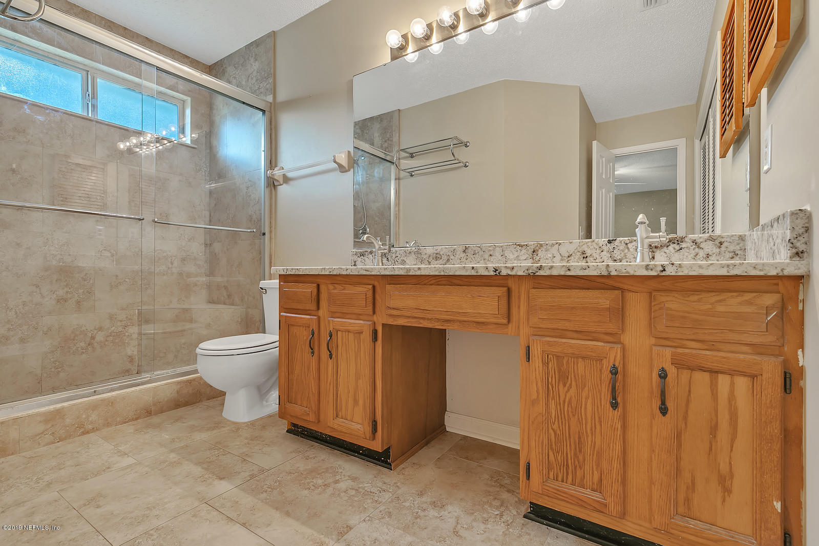 12436 Running River Road South Jacksonville, FL 32225 - Photo 15 of 25 a spacious bathroom with a granite countertop sink a toilet and a mirror